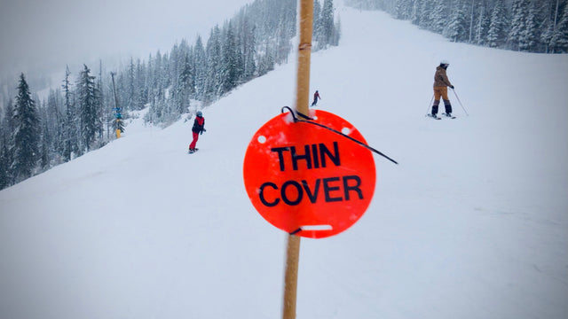 The real orange Thin Cover sign on its pole on a ski run
